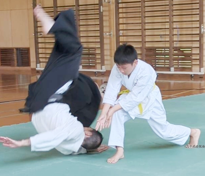 合気道　投げ技の稽古をする子供