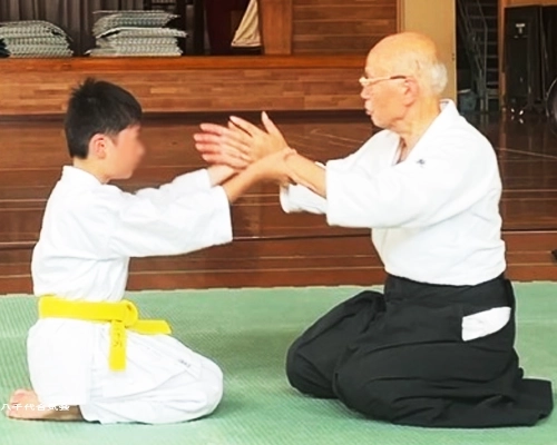 少年部の稽古風景。先生と合気道の稽古をする男の子。